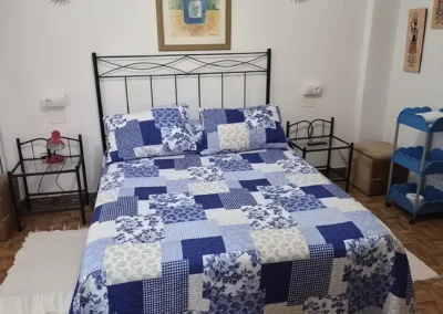 Habitación con cama de matrimonio en el Hostal Louro en Ordes, equipada con mesillas y decoración cuidada.